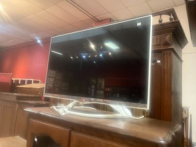un grand téléviseur à écran plat posé sur un meuble TV en bois