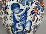 a blue and white vase with a child on it