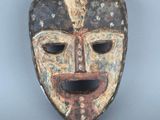 une image représentant un masque en bois sur fond gris