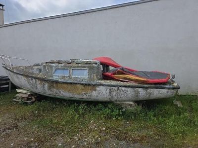 un bateau posé dans l'herbe à côté d'un bâtiment
