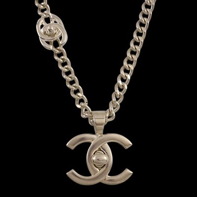 a silver necklace with a chain that has a chanel logo on it