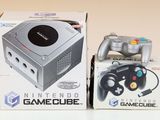 une Nintendo GameCube à côté d'une boîte contenant une manette de jeu