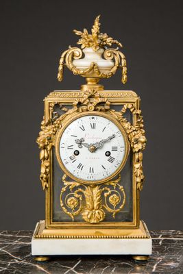 a gold and white clock on a marble table