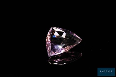 gros plan d'un diamant rose sur une surface noire