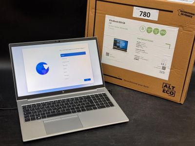 un ordinateur portable posé à côté d'une boîte sur une table