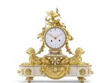 une horloge dorée et blanche posée sur un socle, entourée de statues