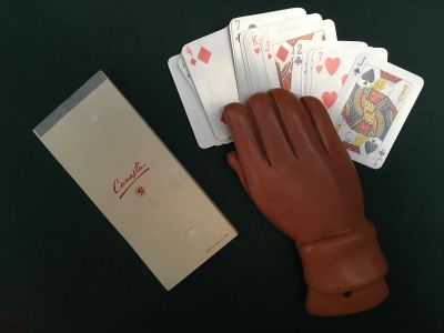 une main tenant des cartes à jouer à côté d'une boîte