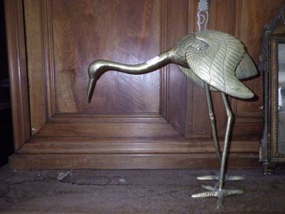 a metal bird that is standing on a table