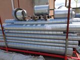 une grande pile de tuyaux métalliques posée sur un chariot rouge
