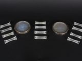 four pieces of silver and blue glass are arranged on a black surface