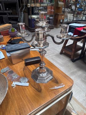 a table with a silver plate and a silver candelabra on it