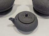 three black teapots sitting on a white table