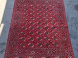 Un tapis oriental est posé par terre, au soleil.