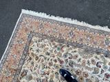 a cat that is sitting on a rug on the ground