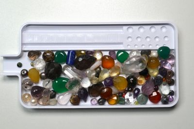 un récipient blanc rempli de nombreuses pierres de différentes couleurs