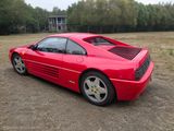 a picture of a red sports car parked in a field
