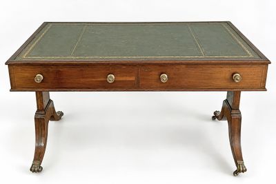 an antique writing table with two drawers and a leather top