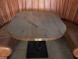 une table en bois avec un banc en bois dans un coin d'une alcôve