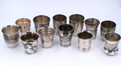 Plusieurs coupes en argent sont alignées sur une surface blanche