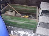a green box with a baseball bat in it next to a pile of tires