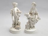 paire de figurines en porcelaine blanche représentant un homme et une femme accompagnés d'un chien