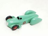 a green toy car that is sitting on a white surface