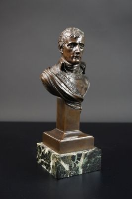 un buste en bronze représentant un homme, posé sur un socle en marbre