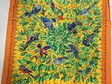 un gros plan sur une écharpe jaune ornée d'oiseaux