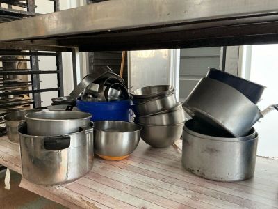 many pots and pans sitting on a shelf in a kitchen