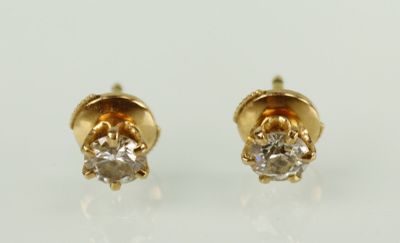 une paire de boucles d'oreilles en diamant sur une surface blanche