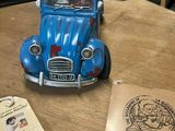 a blue toy car sitting on top of a wooden table