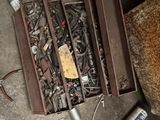 une boîte remplie de vis et d'autres outils posée par terre