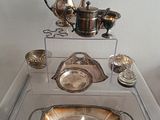 une table en verre sur laquelle sont posés des objets en argent