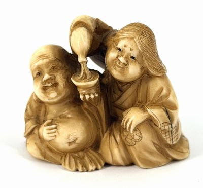 two figurines of a boy and a girl sitting on the ground
