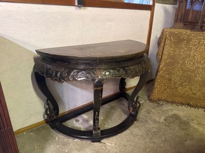 a small table with a wooden top in the corner of a room