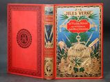 un vieux livre rouge avec une couverture dorée sur laquelle figure une horloge dorée