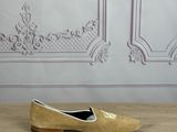 yellow shoes on a wooden table in front of a white wall