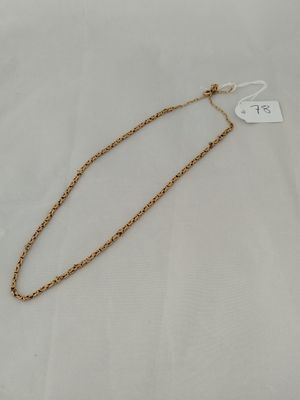 a gold chain necklace with a white tag on it