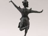 a bronze statue of a dancer on a pedestal
