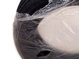 a plastic bag on top of a tire that is wrapped in plastic