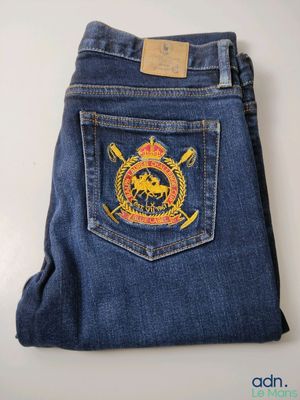 la poche arrière d'un jean sur laquelle est épinglé un insigne