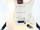 an electric guitar sitting on top of a stand on a white surface