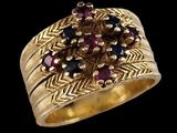 a close up of a gold ring with garnets on it