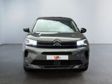 the front view of a grey citrole parked in a white room