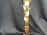un vase doré orné de fleurs sur fond noir