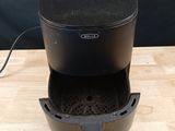 an image of a black air fryer sitting on a wooden table