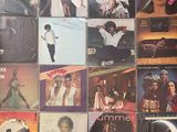 many different album covers on the wall of a room