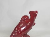 a red bird figurine sitting on top of a white table