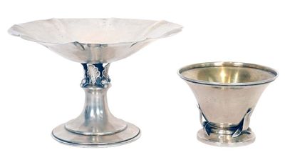 two silver vases sitting next to each other on a white surface