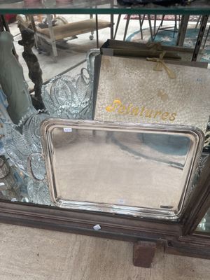 a silver tray with a mirror on it in a store window